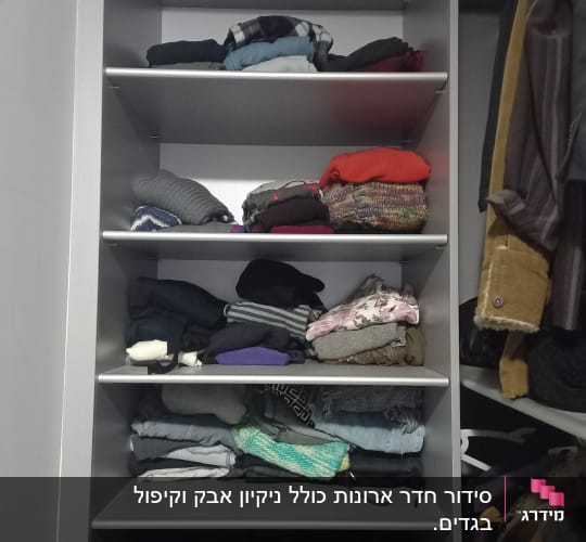 בגדים מקופלים על מדפים בארון פתוח